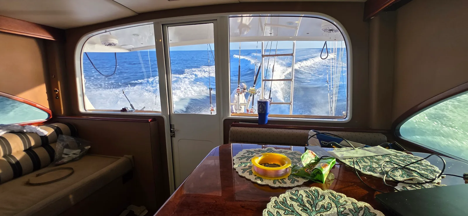 View from the salon window toward the cockpit and wake while underway on a Daniel's Legacy sportfishing charter off Quepos, Costa Rica